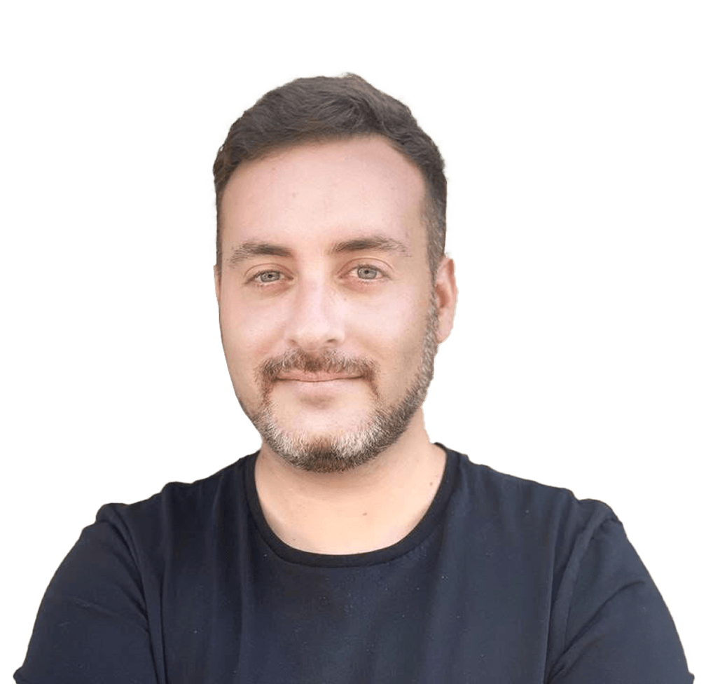 Man with short hair and a beard, wearing a black shirt, smiling with arms crossed against a plain white background.