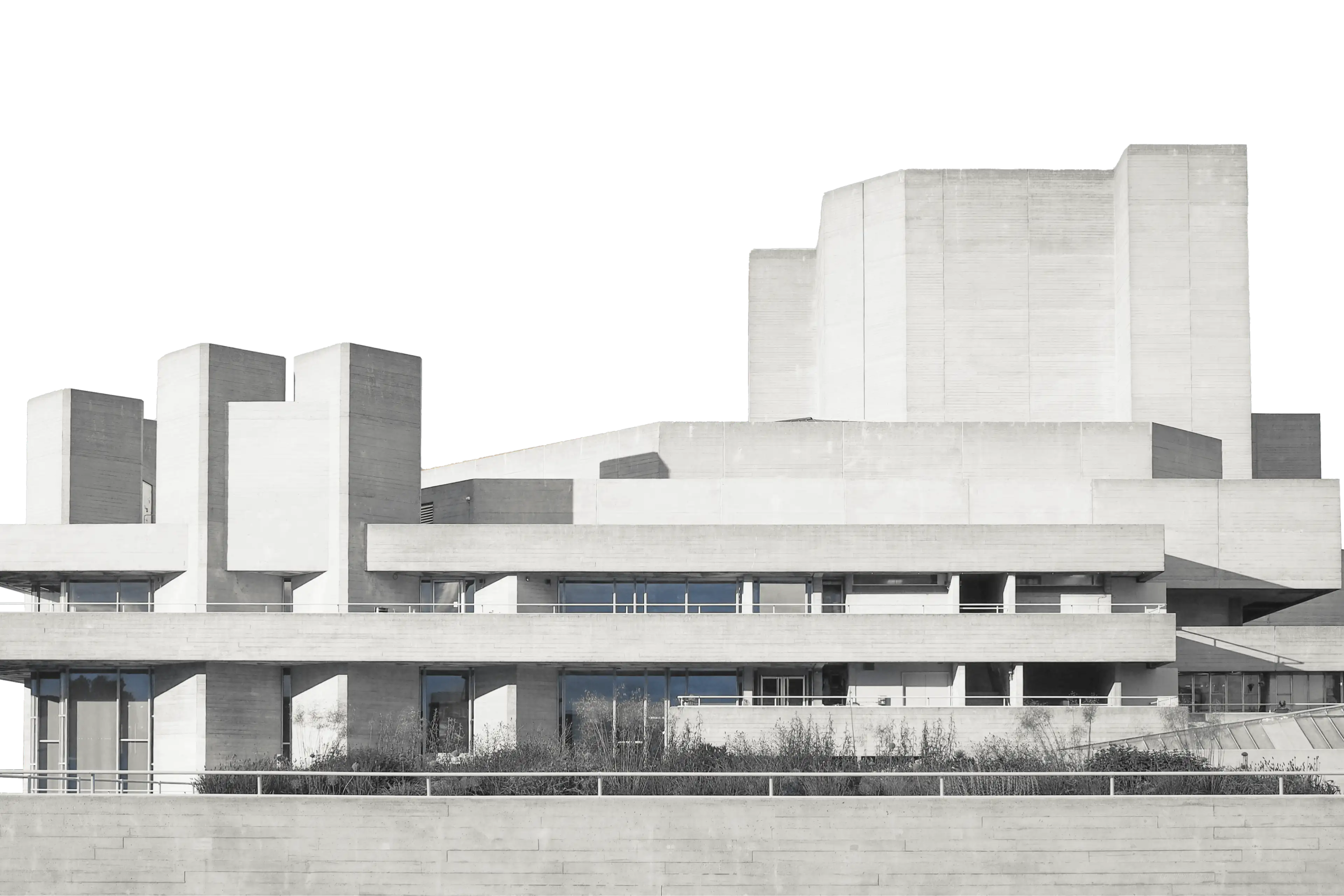 A modernist concrete building with terraced balconies against a pale sky