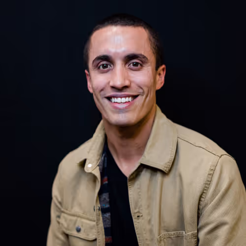 Author headshot of a man wearing a tan jacket against a dark background.