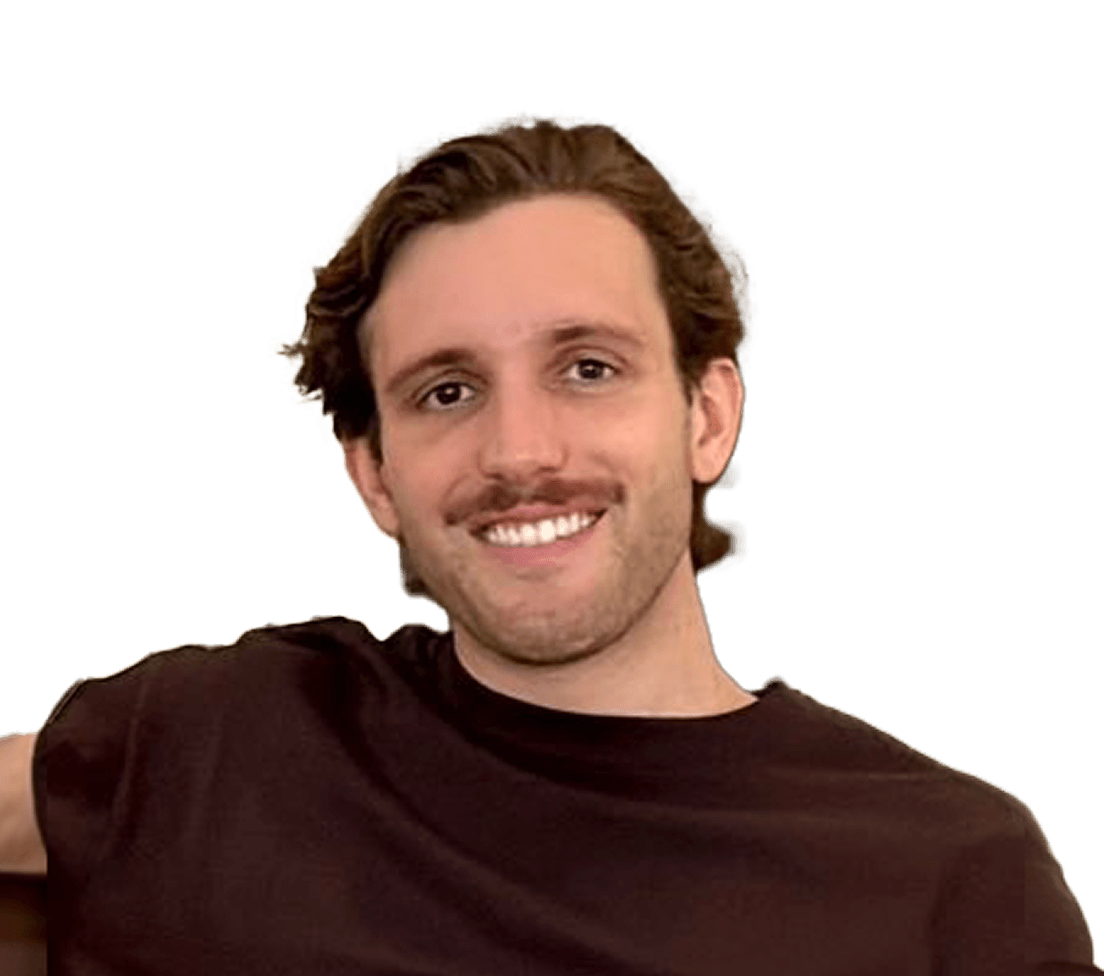 Smiling man with wavy hair and a beard, wearing a black shirt, against a plain background.
