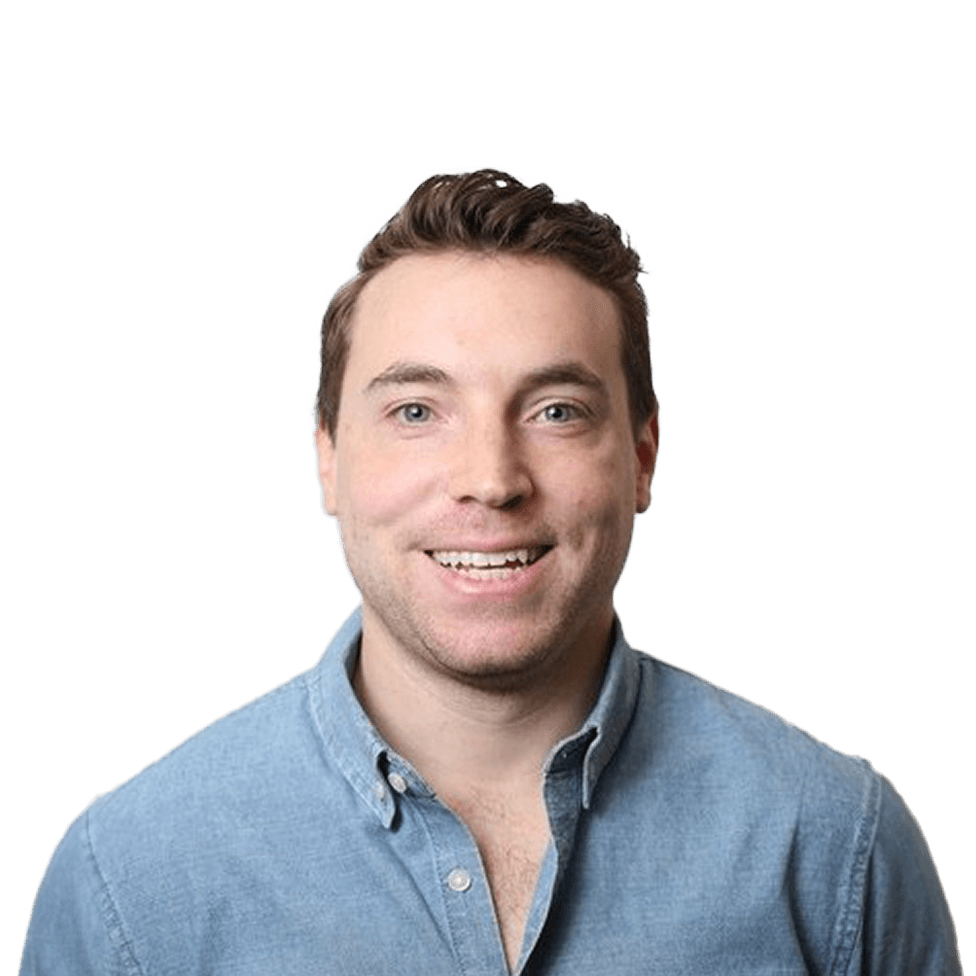 Smiling man with short hair wearing a light blue button-up shirt against a plain white background.